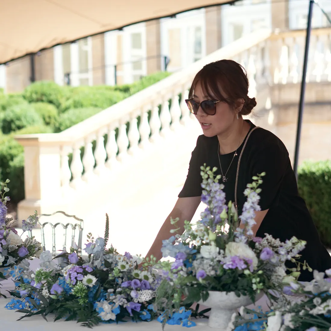 Karen styling a floral table arrangement at an outdoor event