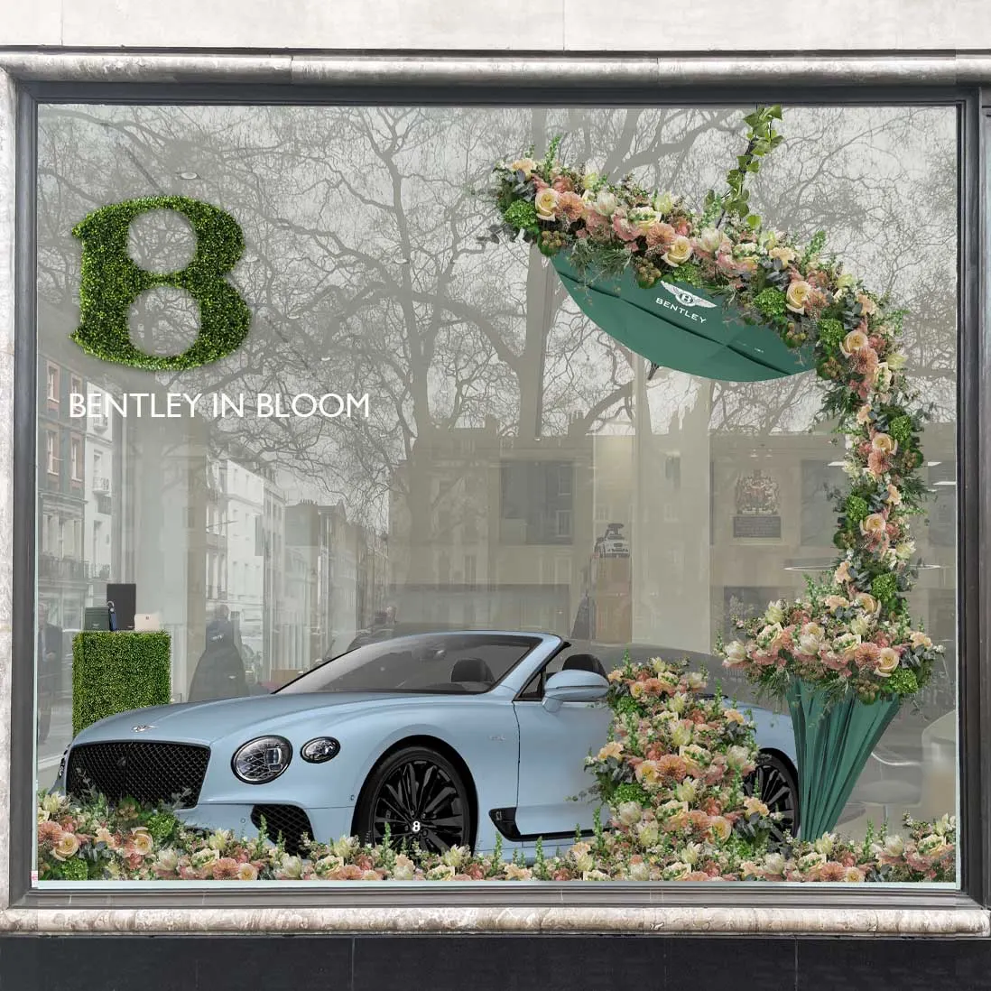 A spring floral window installation banked around a car in a showroom window
