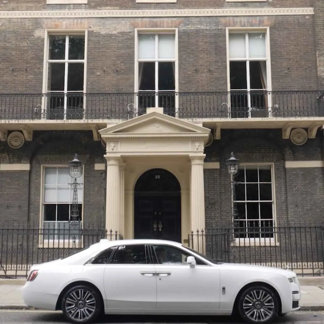 A Georgian townhouse frontage with a white car parked outside