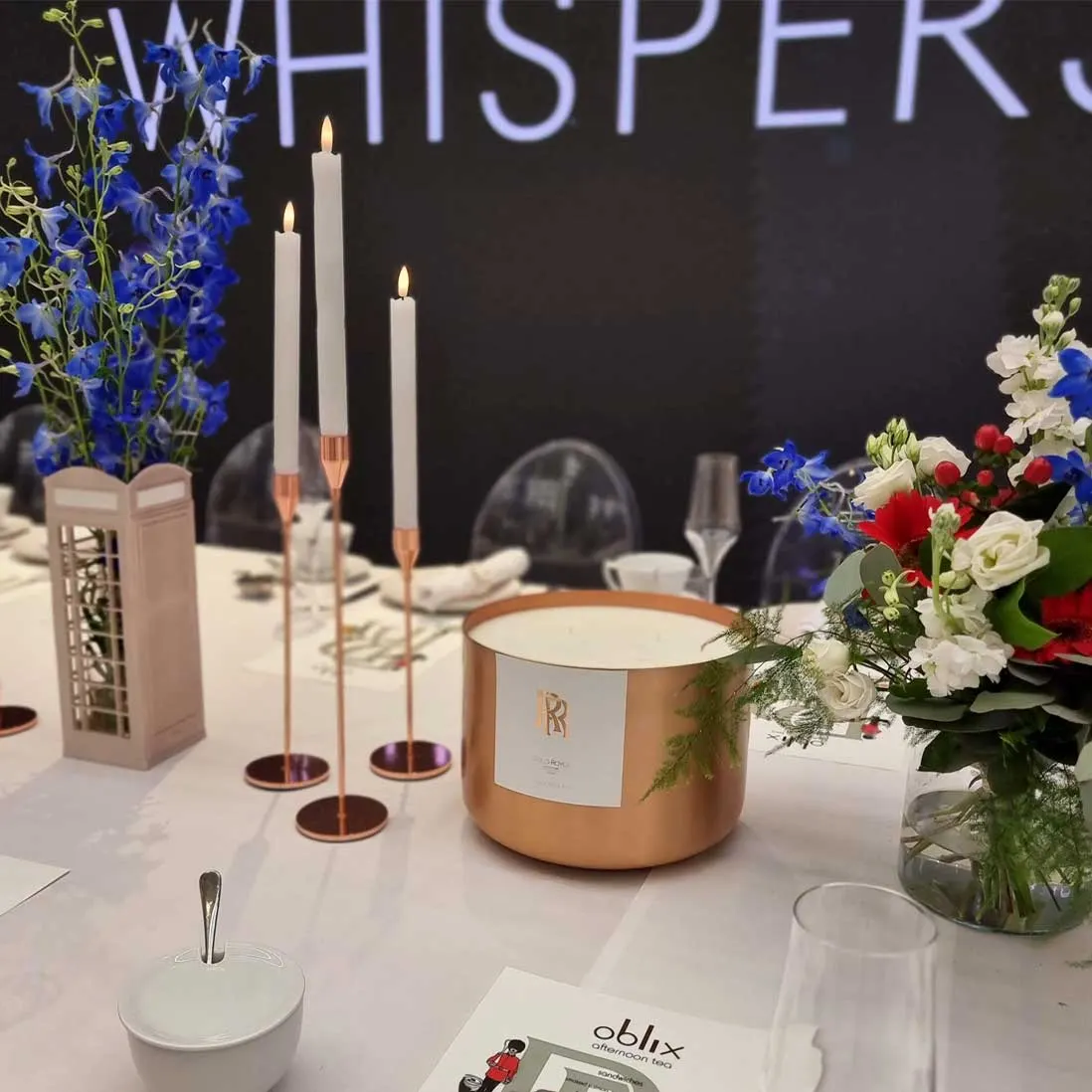 Copper candles and blue and white florals along a dressed table