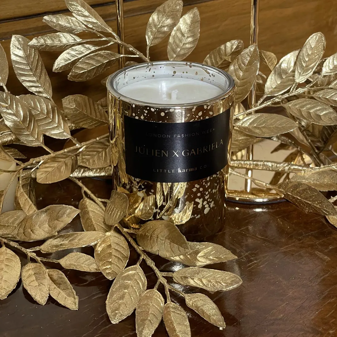 A black scented candle set among gilded foliage