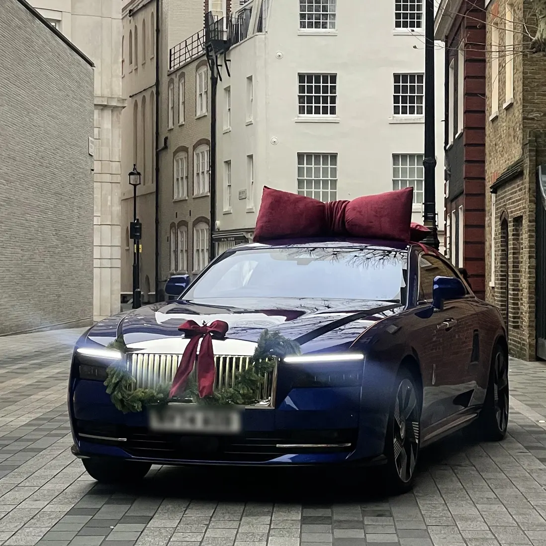 A single car dressed with a fabric bow and a foliage garland
